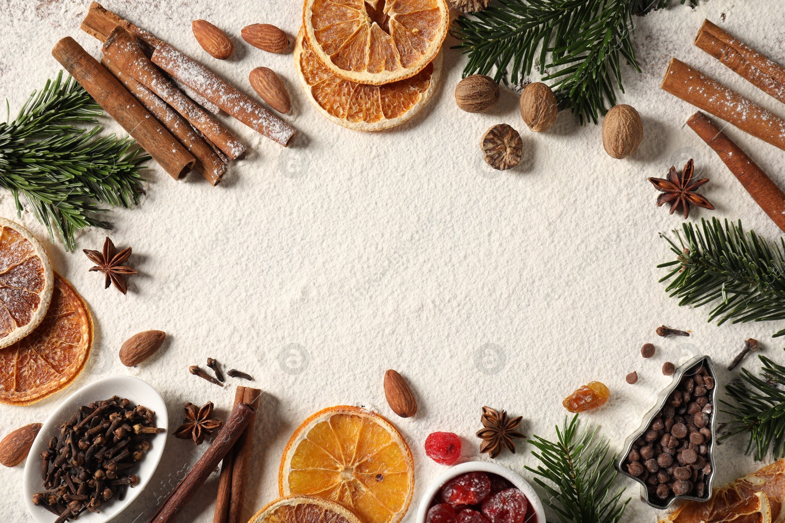 Photo of Frame of different aromatic spices and fir tree branches on table, flat lay with space for text. Christmas season