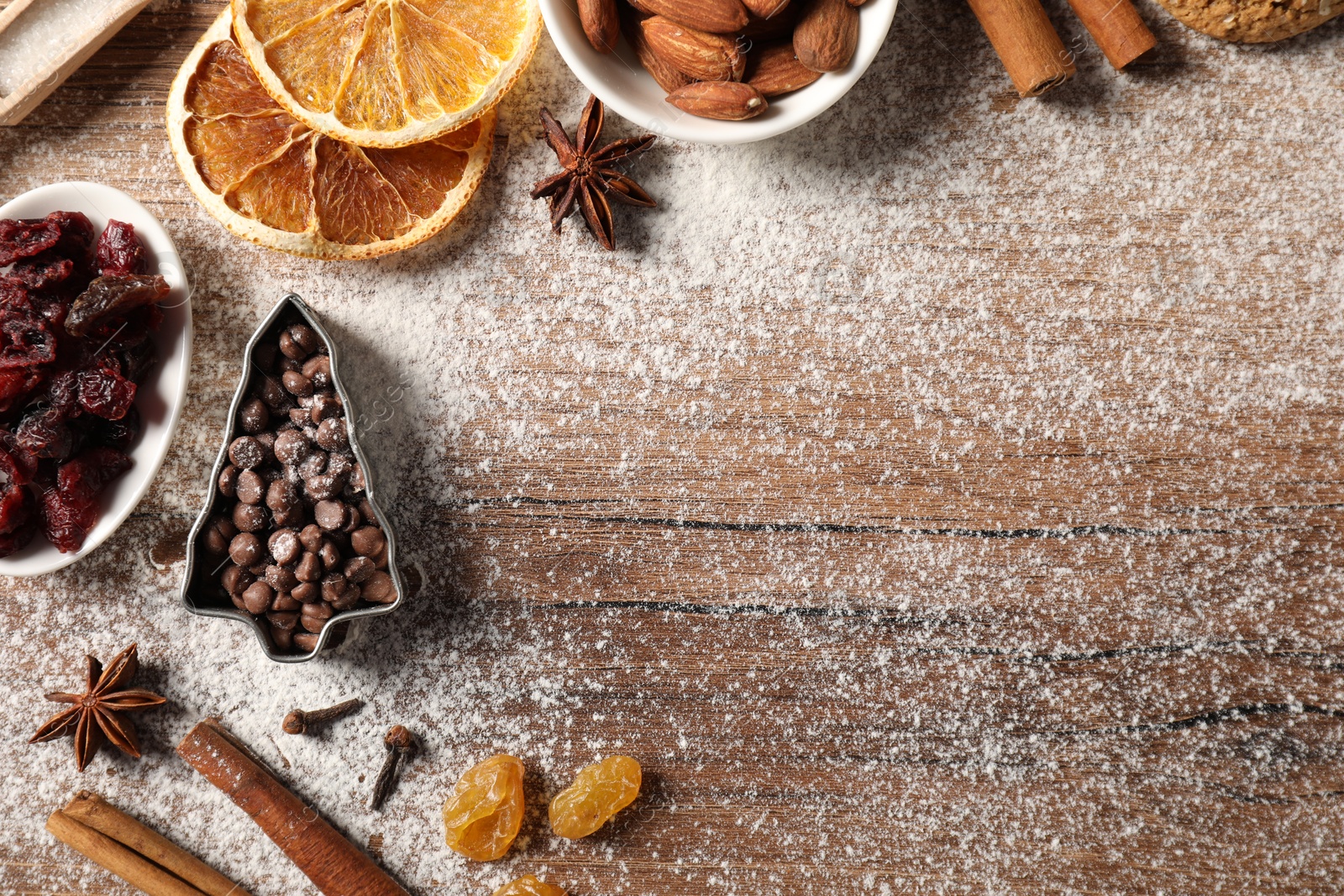 Photo of Different aromatic spices on wooden table, flat lay with space for text. Christmas season