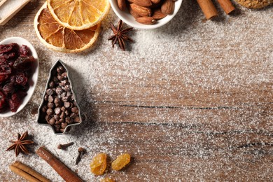 Photo of Different aromatic spices on wooden table, flat lay with space for text. Christmas season