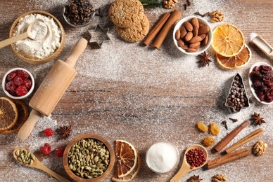 Photo of Frame of different aromatic spices on wooden table, flat lay. Christmas season