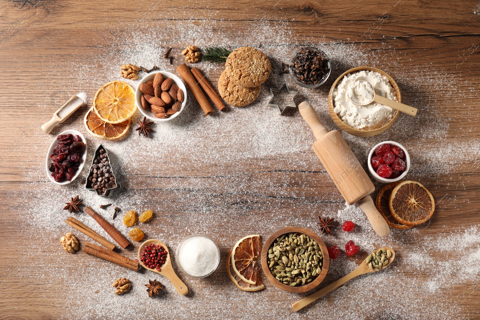 Photo of Frame of different aromatic spices on wooden table, flat lay. Christmas season