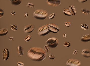 Image of Aromatic roasted coffee beans in air on brown background