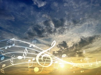 Image of Musical symbols in beautiful sunset sky with clouds