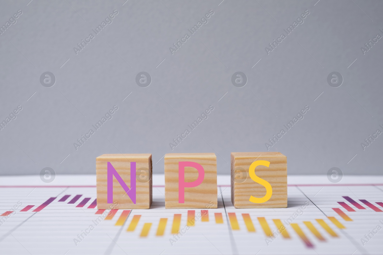 Image of NPS (net promoter score) abbreviation made of cubes against grey background