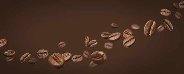 Image of Aromatic roasted coffee beans in air on brown background. Banner design