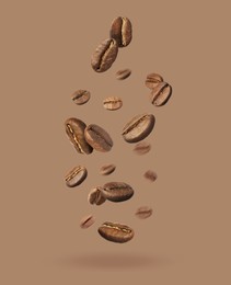 Image of Aromatic roasted coffee beans falling on dark beige background