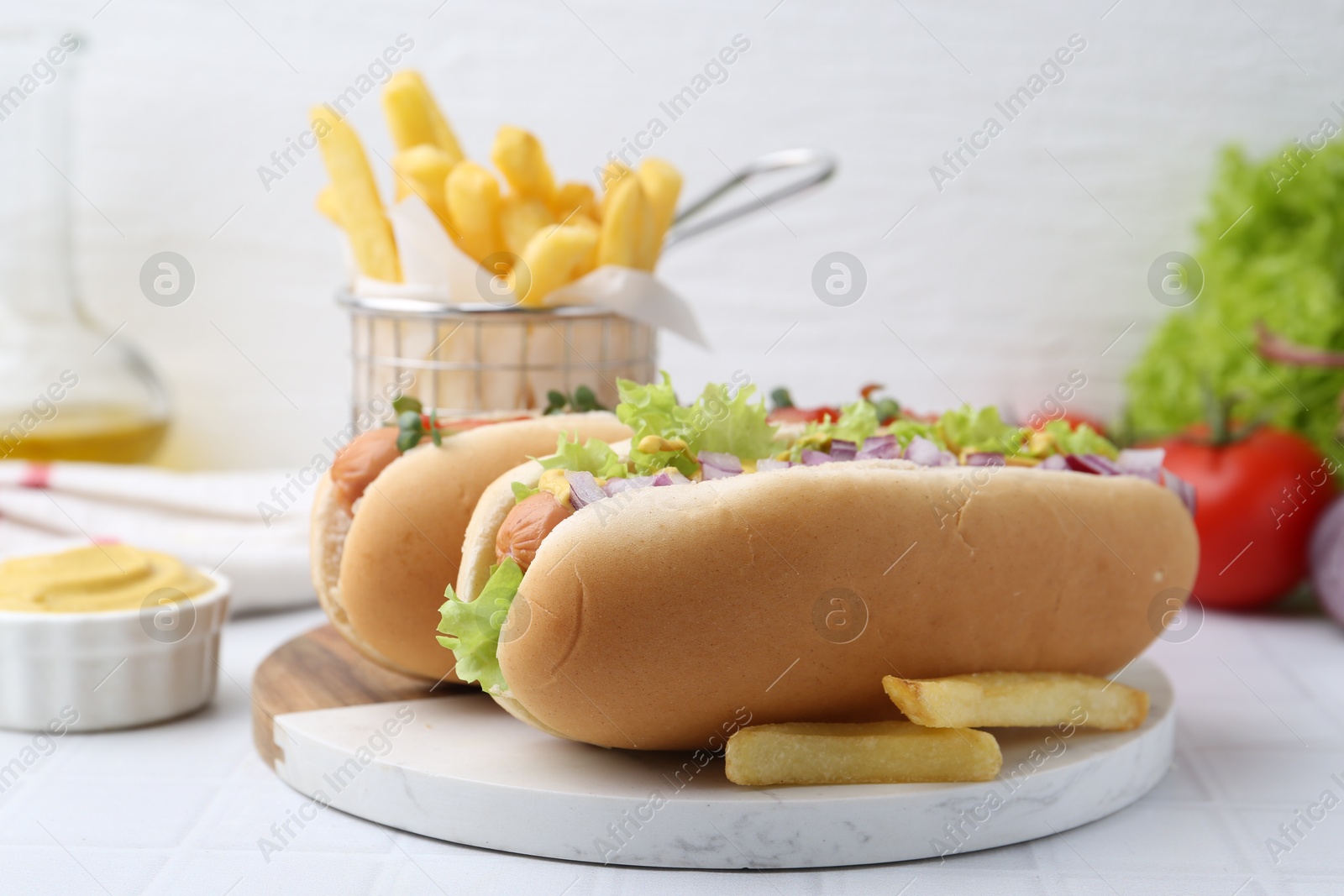 Photo of Tasty hot dogs served on white tiled table