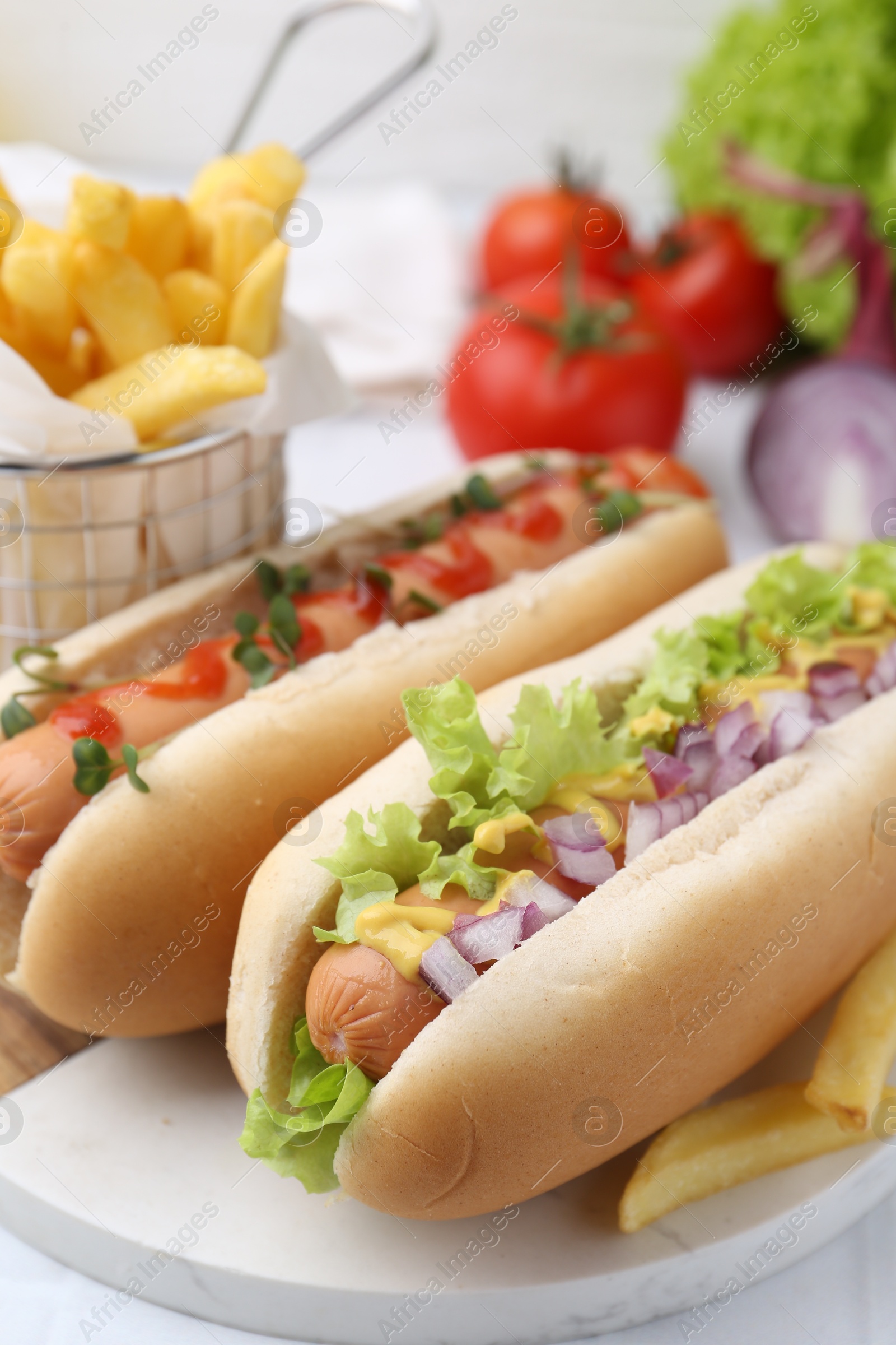 Photo of Tasty hot dogs served on white table, closeup