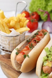 Photo of Tasty hot dogs served on white table, closeup