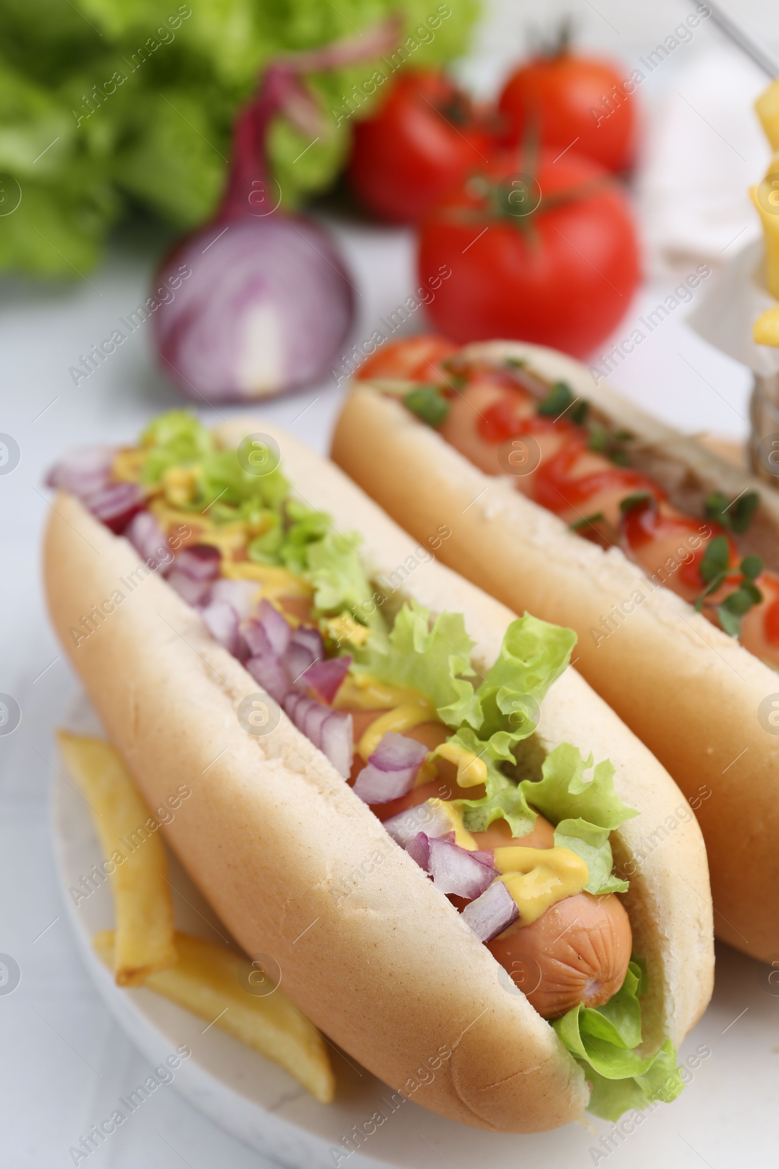 Photo of Tasty hot dogs served on white table, closeup