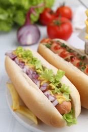 Photo of Tasty hot dogs served on white table, closeup