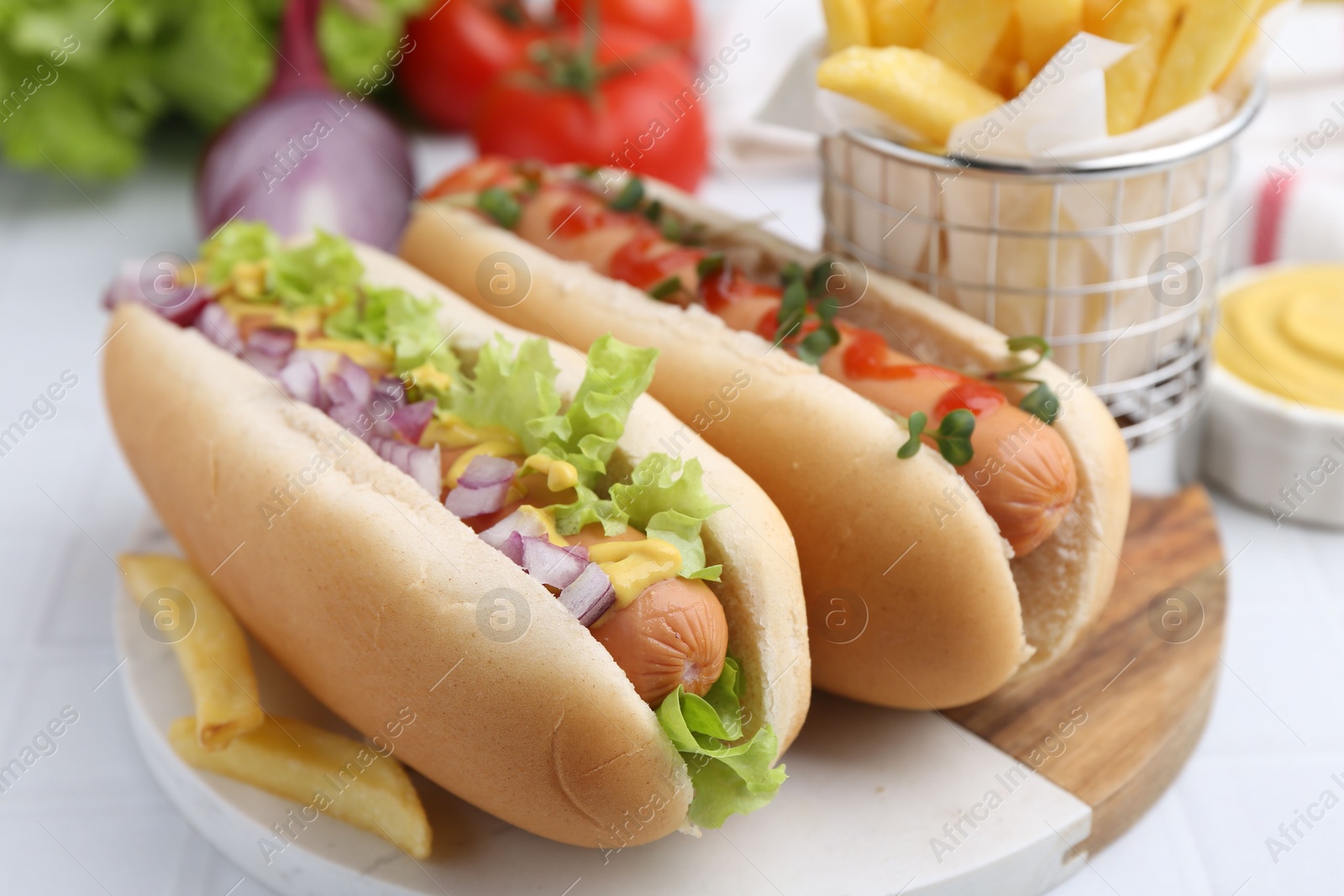 Photo of Tasty hot dogs served on white table, closeup