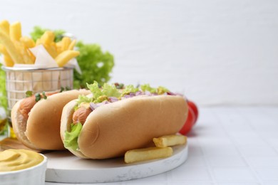 Photo of Tasty hot dogs served on white tiled table. Space for text