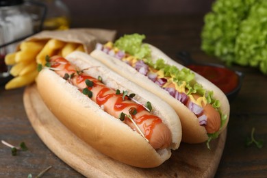 Photo of Tasty hot dogs served on wooden table, closeup