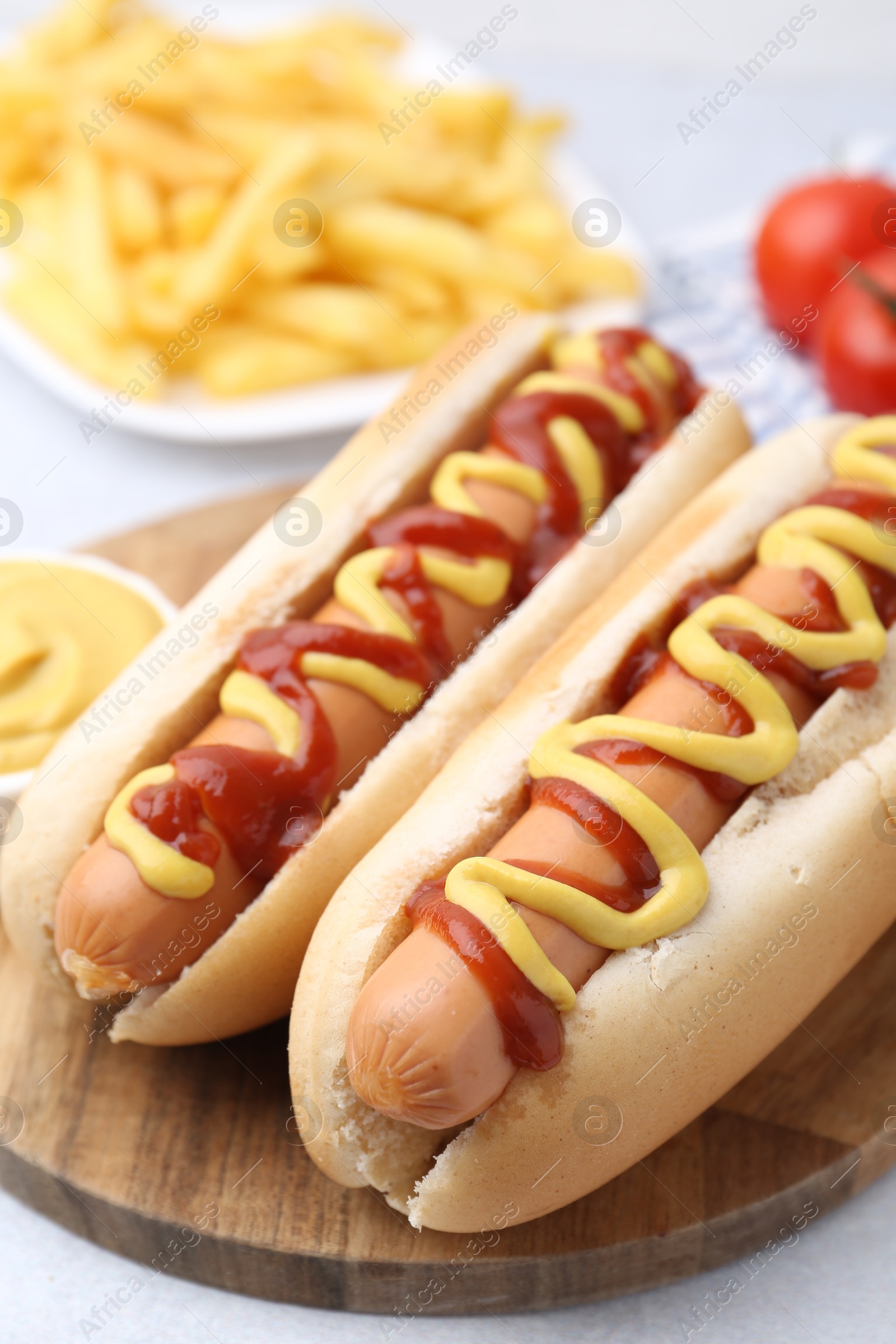 Photo of Tasty hot dogs served on light table, closeup