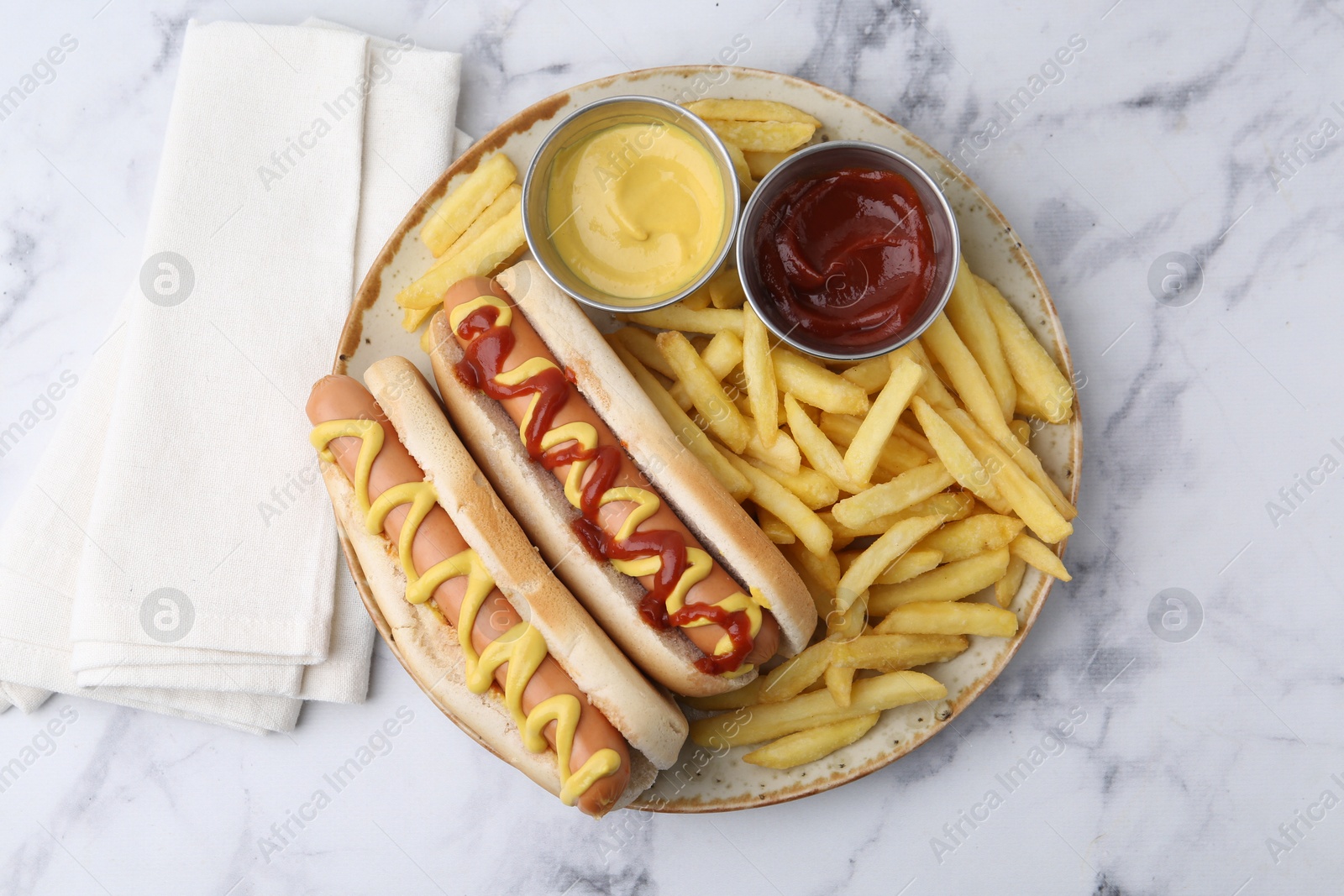 Photo of Tasty hot dogs with fries served on white marble table, top view