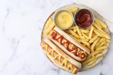 Photo of Tasty hot dogs with fries served on white marble table, top view. Space for text