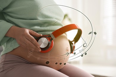 Image of Pregnant woman holding headphones near her belly at home, closeup. Music notes flying around