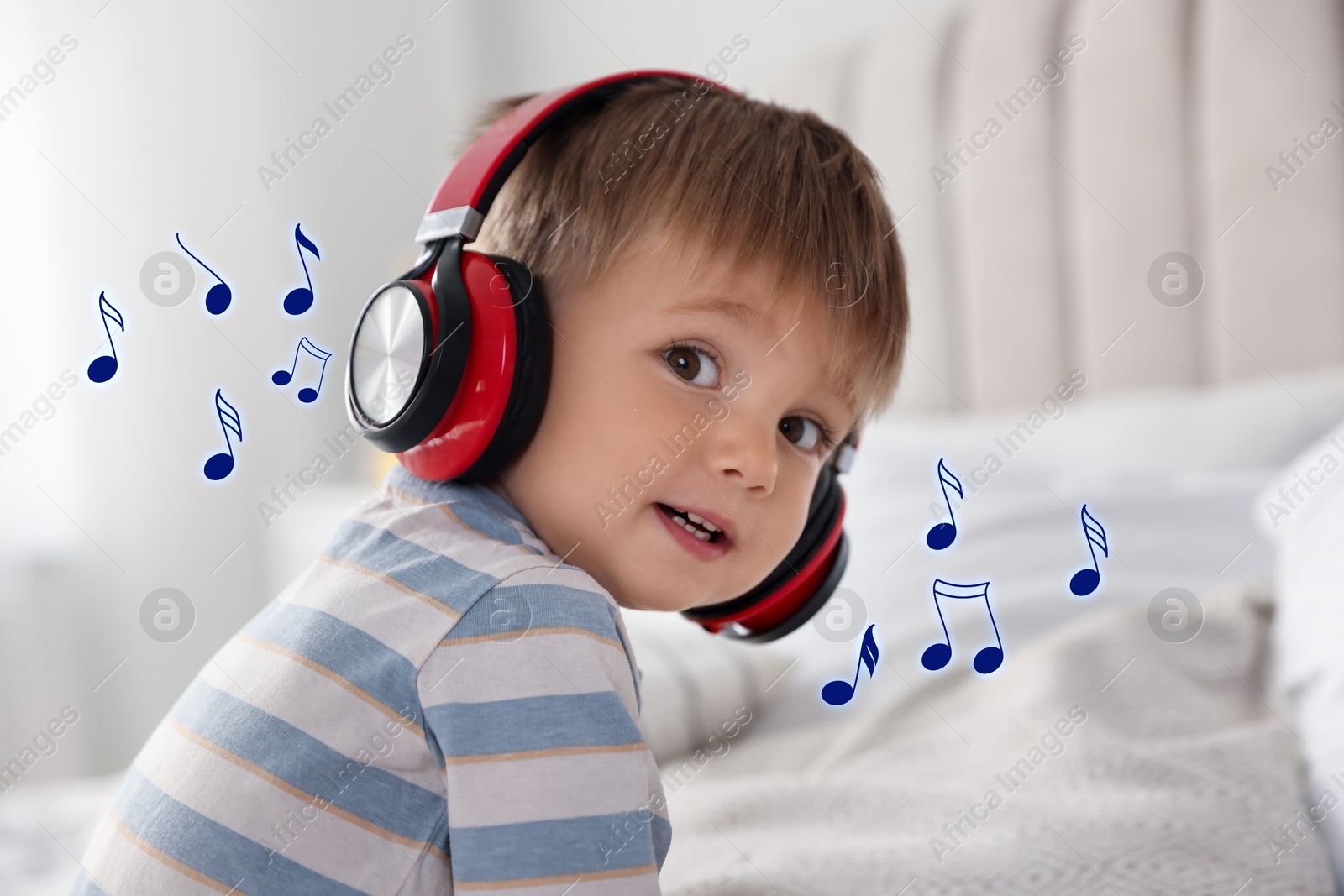 Image of Cute little baby with headphones at home. Music notes flying around