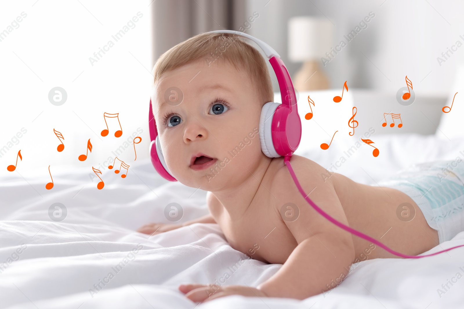 Image of Cute little baby with headphones on bed at home. Music notes flying around