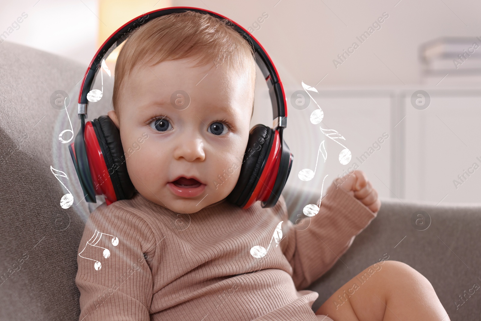 Image of Cute little baby with headphones on sofa at home. Music notes flying around