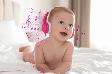 Image of Cute little baby with headphones on bed at home. Music notes flying around