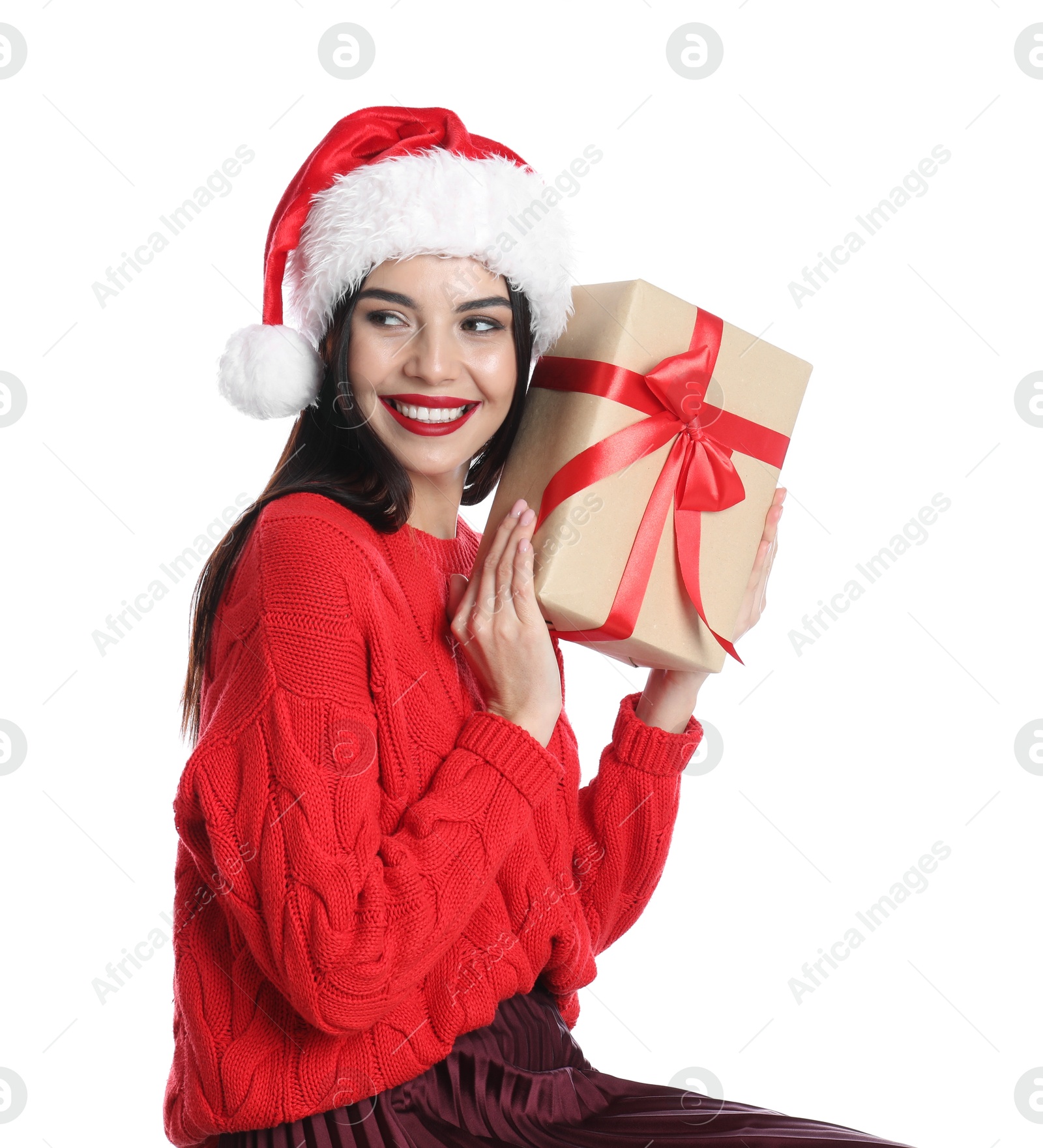 Photo of Woman in Santa hat and red sweater holding Christmas gift on white background