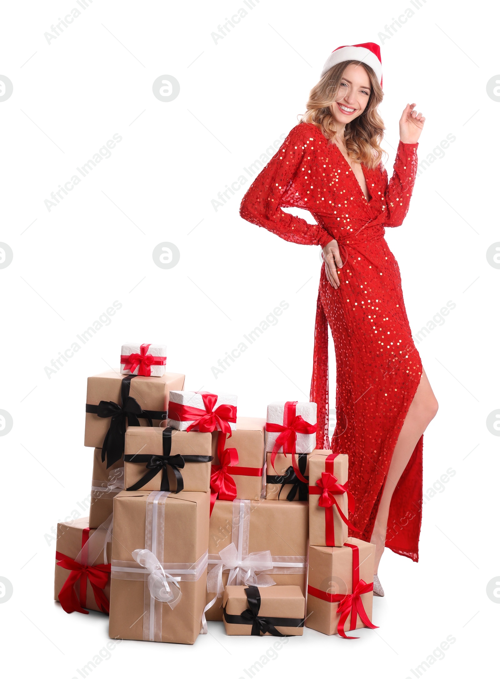 Photo of Beautiful young woman in Santa hat with pile of Christmas presents on white background