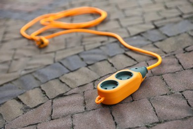 Photo of One extension cord on paved pathway outdoors