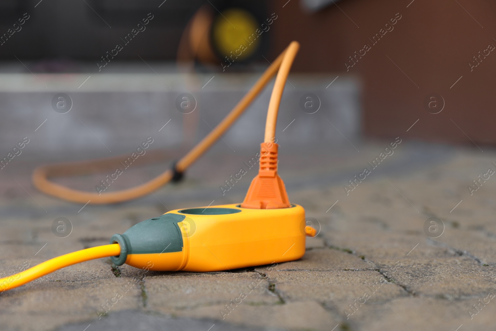 Photo of Extension cord on paved pathway outdoors, closeup