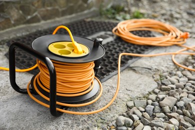 Photo of Extension cord reel on asphalt outdoors, closeup