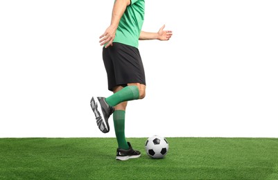 Photo of Man playing football with soccer ball on artificial grass against white background, closeup