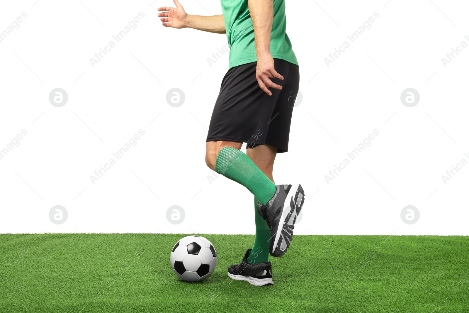 Photo of Man playing football with soccer ball on artificial grass against white background, closeup