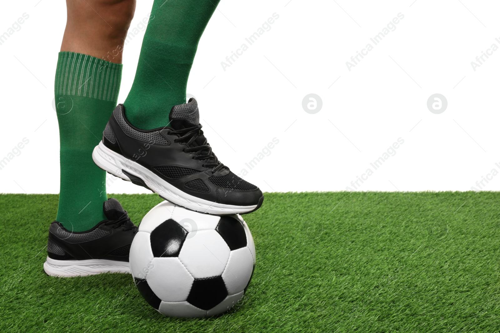 Photo of Football player with soccer ball on artificial grass against white background, closeup