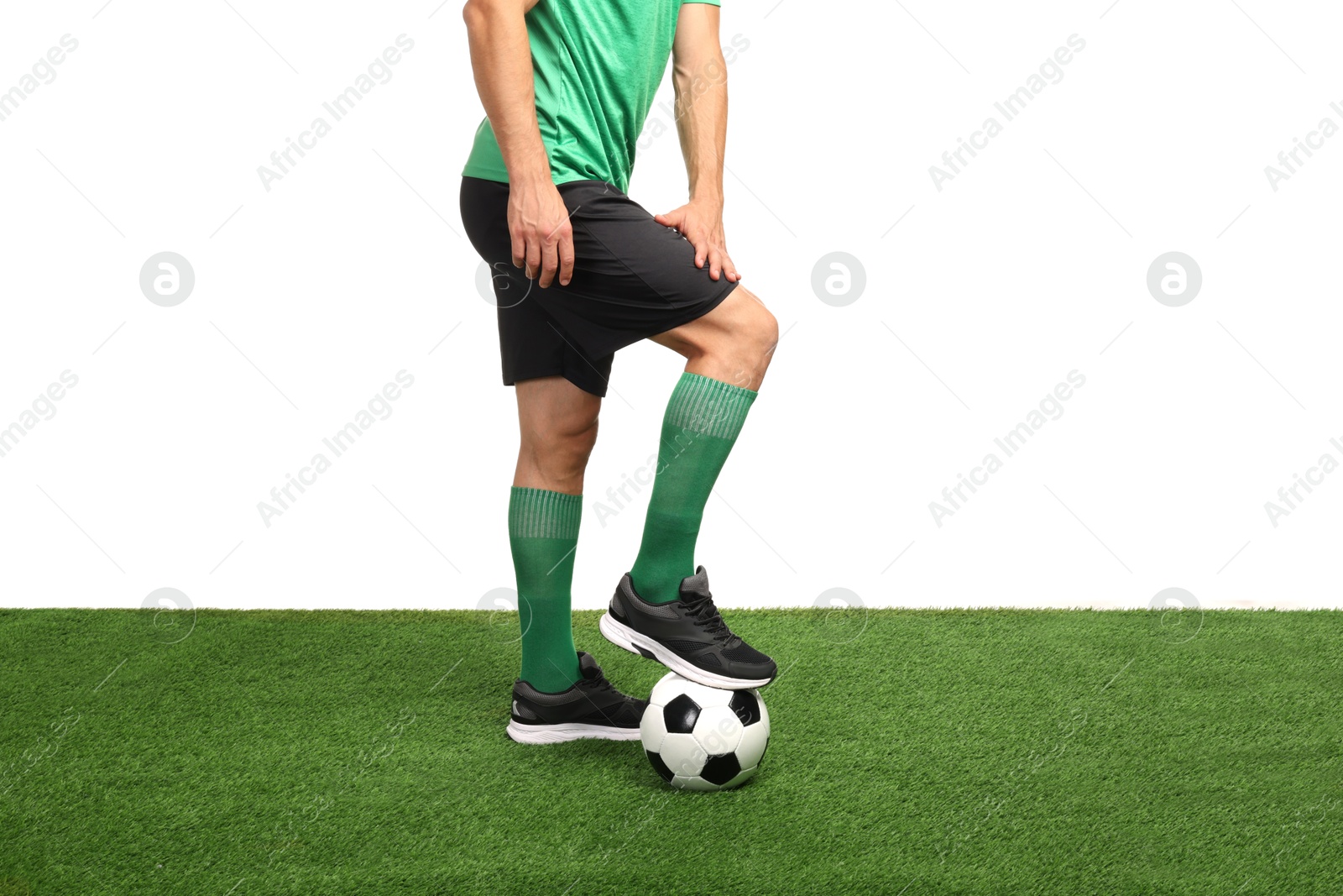 Photo of Football player with soccer ball on artificial grass against white background, closeup