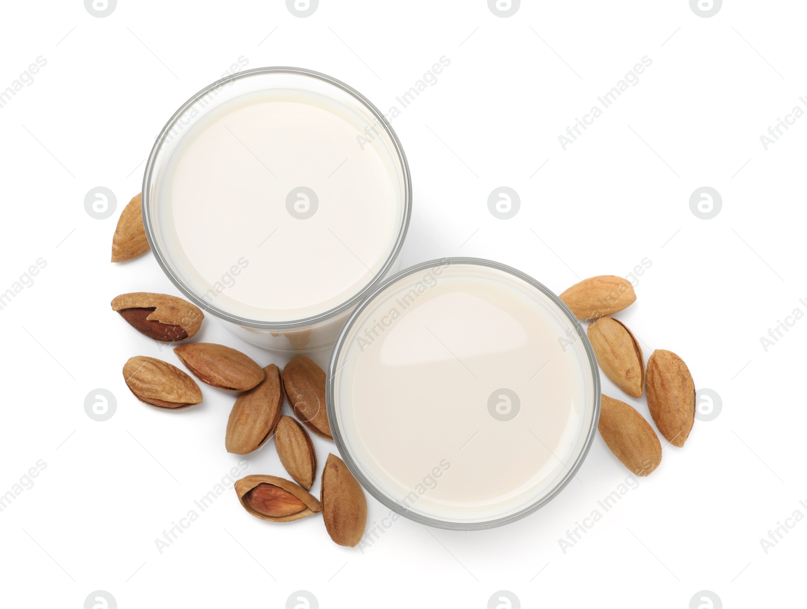 Photo of Glasses of almond milk and nuts isolated on white, top view