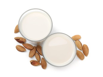 Photo of Glasses of almond milk and nuts isolated on white, top view