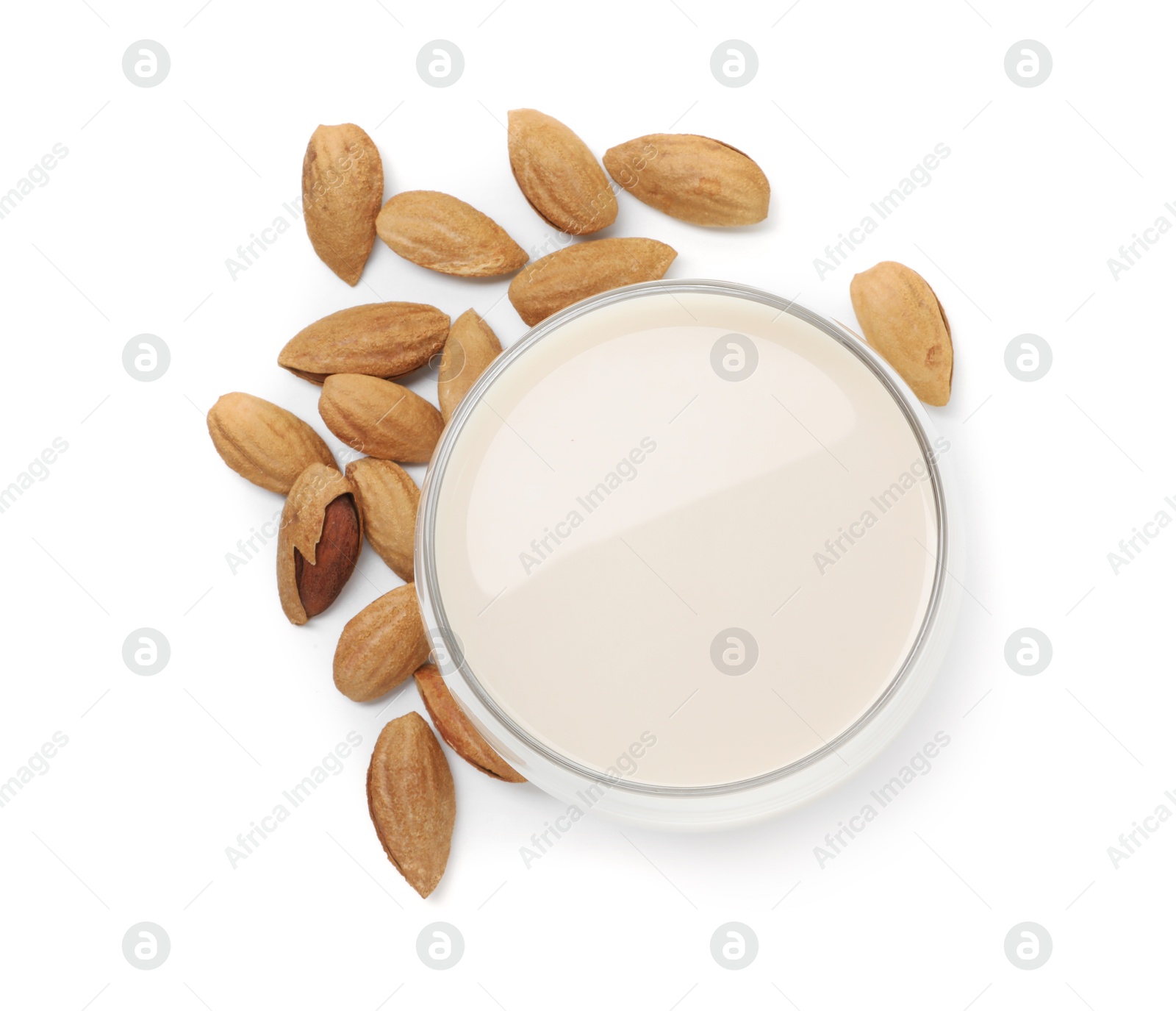 Photo of Glass of almond milk and nuts isolated on white, top view