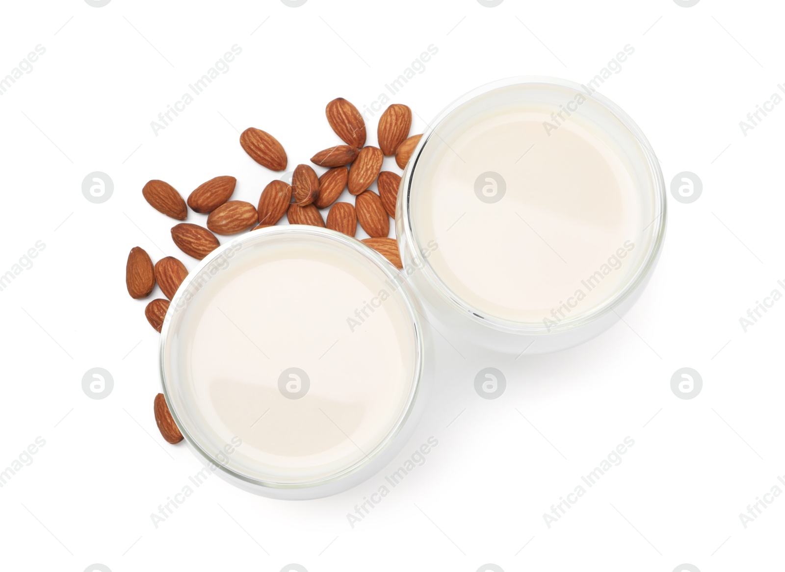 Photo of Glasses of almond milk and nuts isolated on white, top view