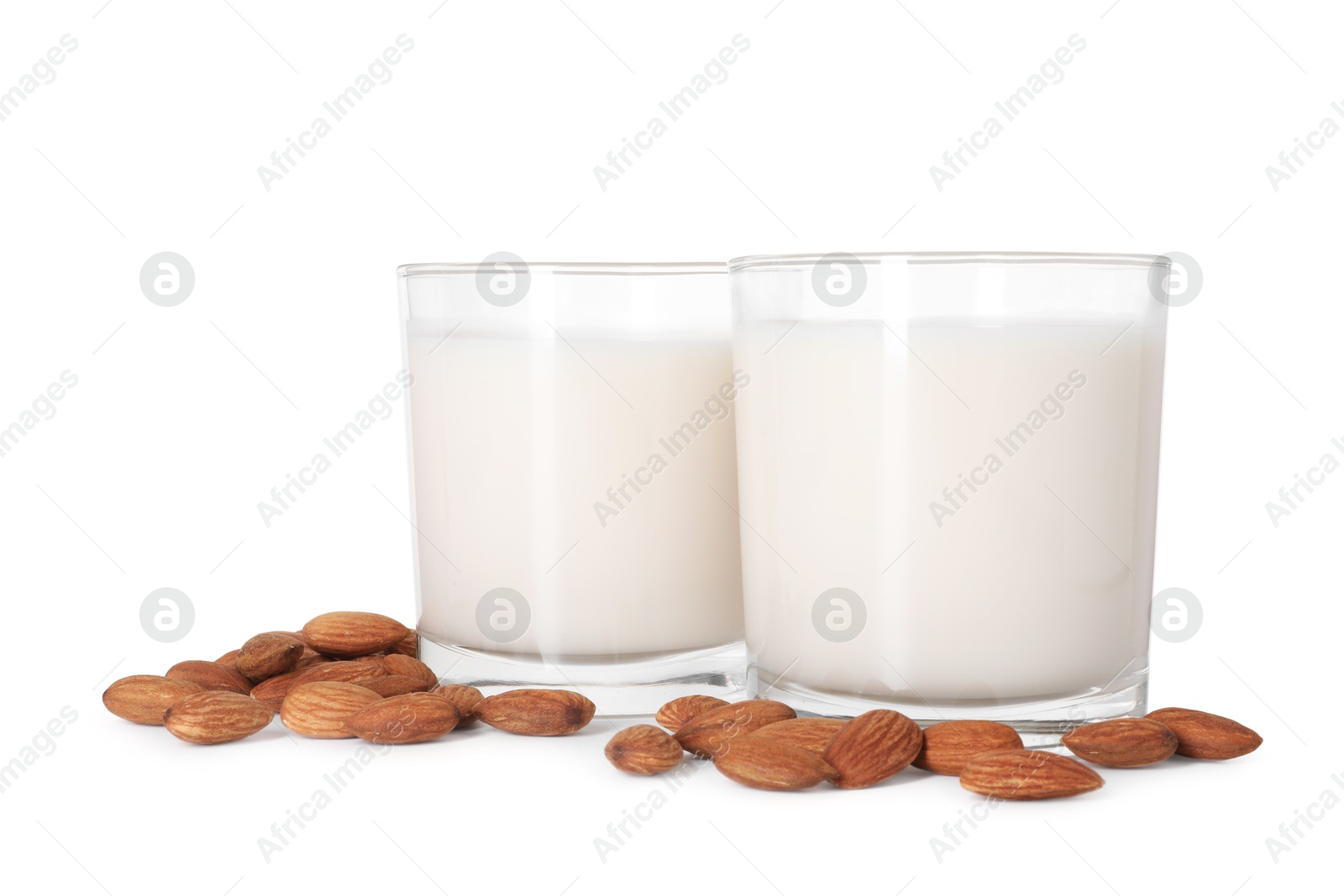 Photo of Glasses of almond milk and nuts isolated on white