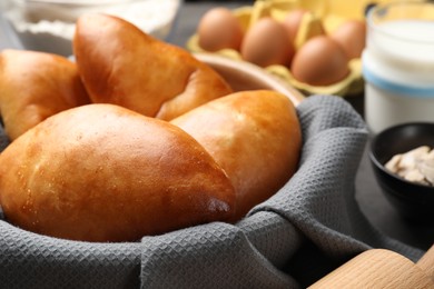 Photo of Delicious pirozhki (stuffed pastry pies) in bowl, closeup