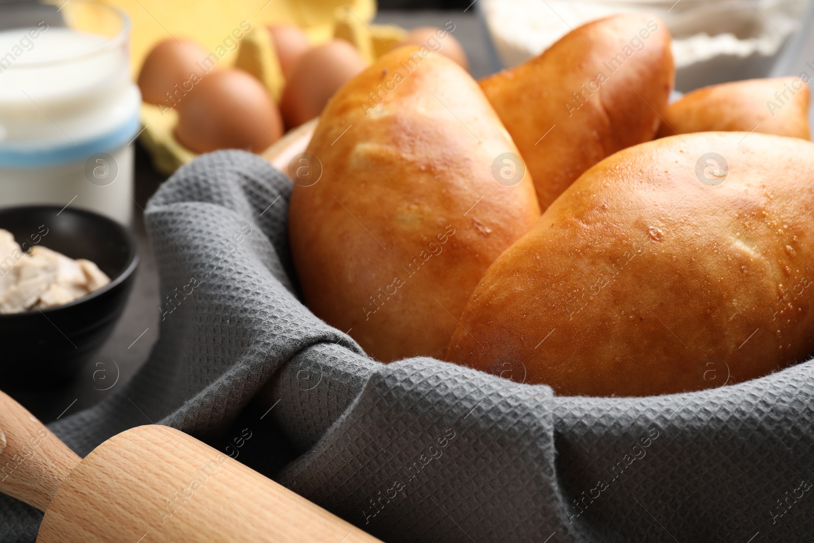 Photo of Delicious pirozhki (stuffed pastry pies) in bowl, closeup