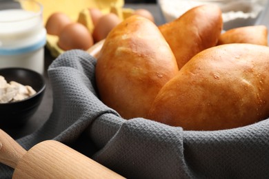 Photo of Delicious pirozhki (stuffed pastry pies) in bowl, closeup