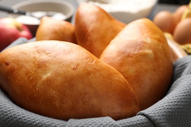 Photo of Delicious pirozhki (stuffed pastry pies) in bowl, closeup