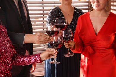 Photo of People clinking glasses of red wine at party, closeup