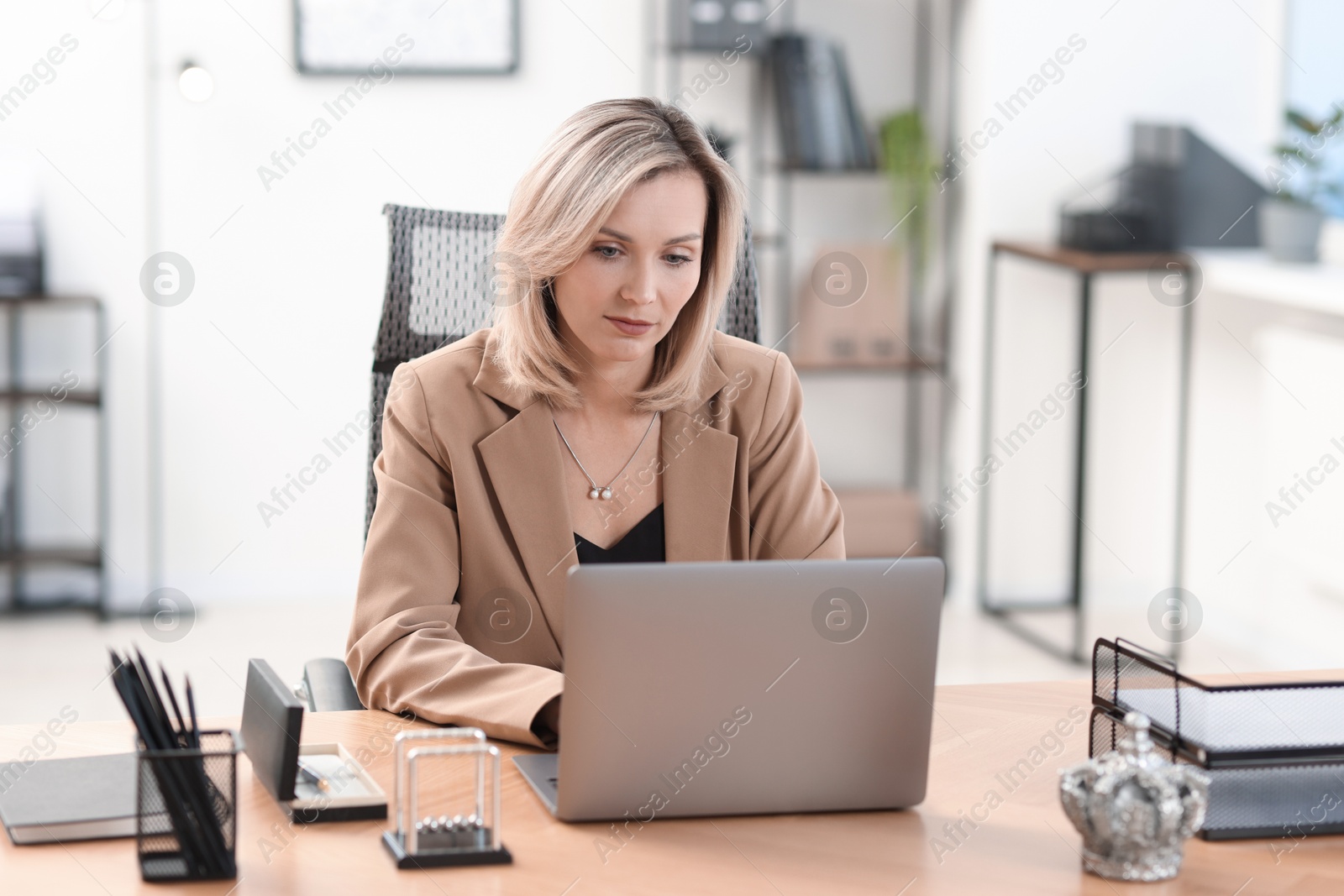 Photo of Businesswoman working on laptop at table in office