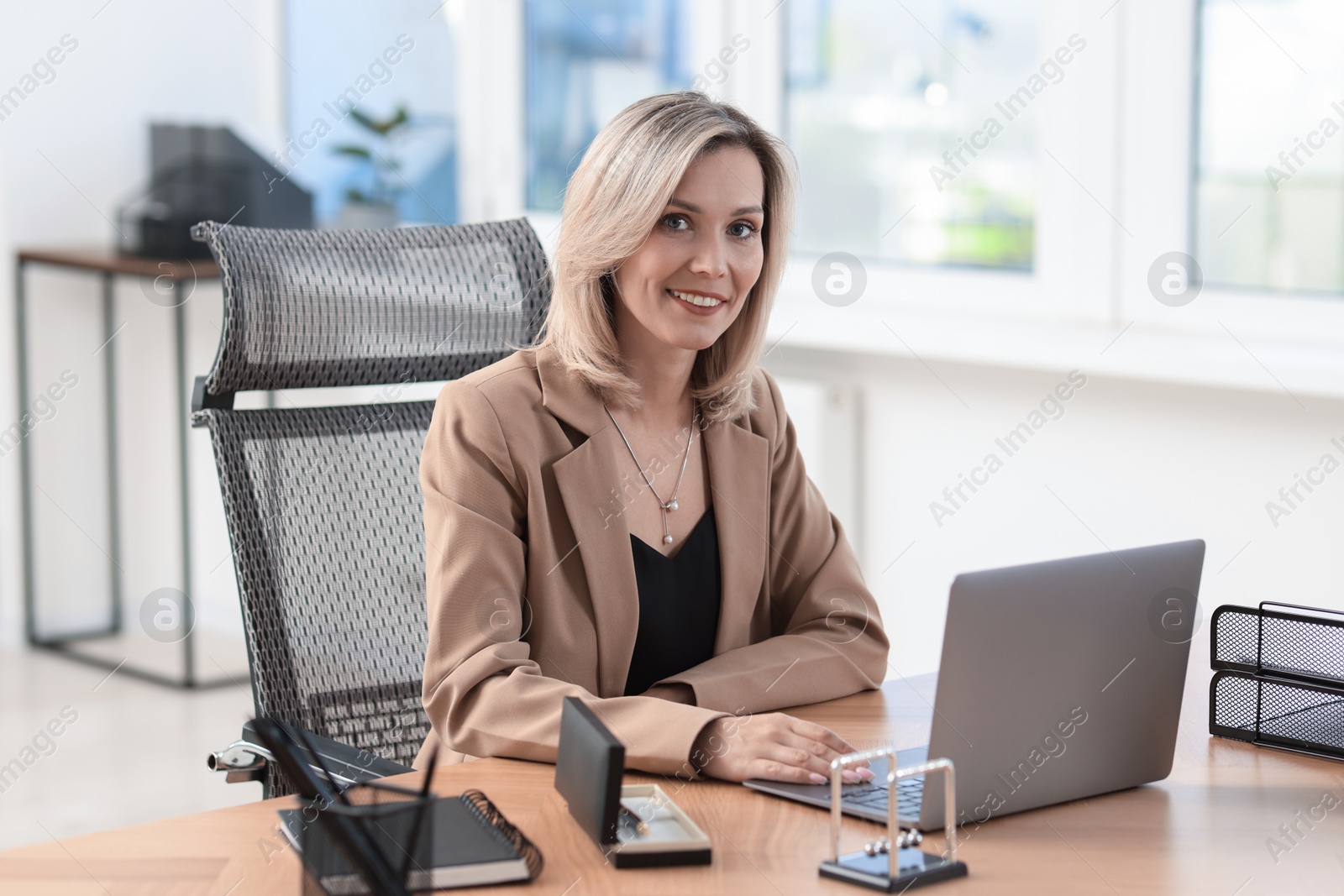 Photo of Businesswoman working on laptop at table in office