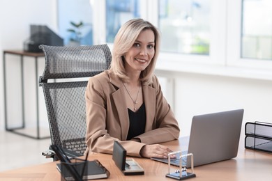 Businesswoman working on laptop at table in office