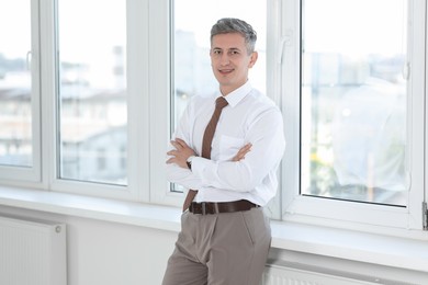 Photo of Portrait of businessman near window in office