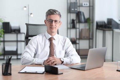 Photo of Portrait of businessman at table in office